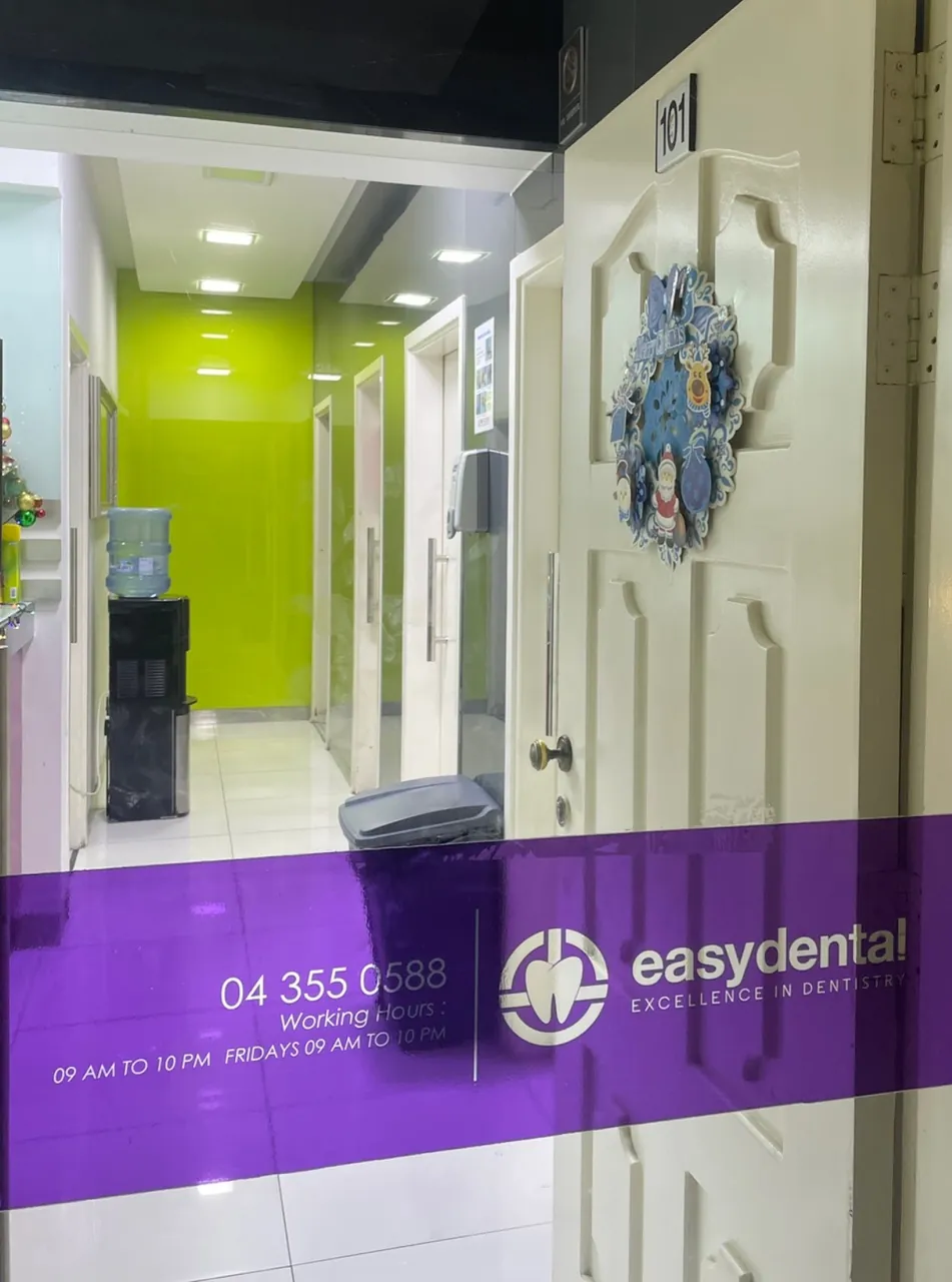 Glass entrance door with the Easy Dental logo and phone number