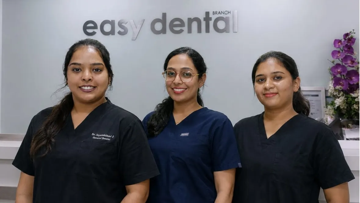 Three team members in scrubs in front of the Easy Dental sign
